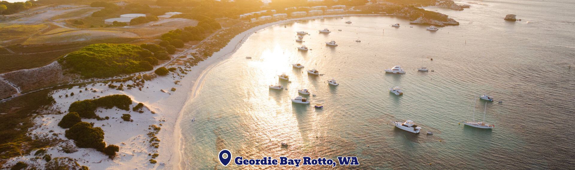 Aerial view of a coastal area with boats in Geordie Bay, Rotto, WA during sunset.